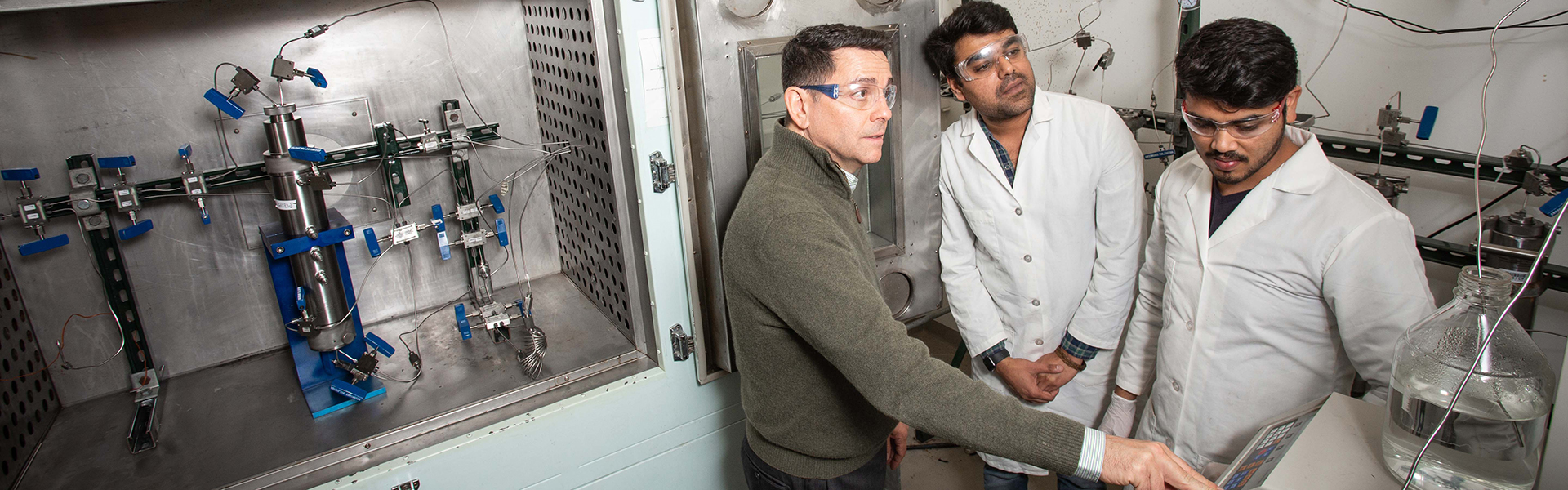 Image of Dr. Konstantinos Kostarelos and two student researchers in the lab